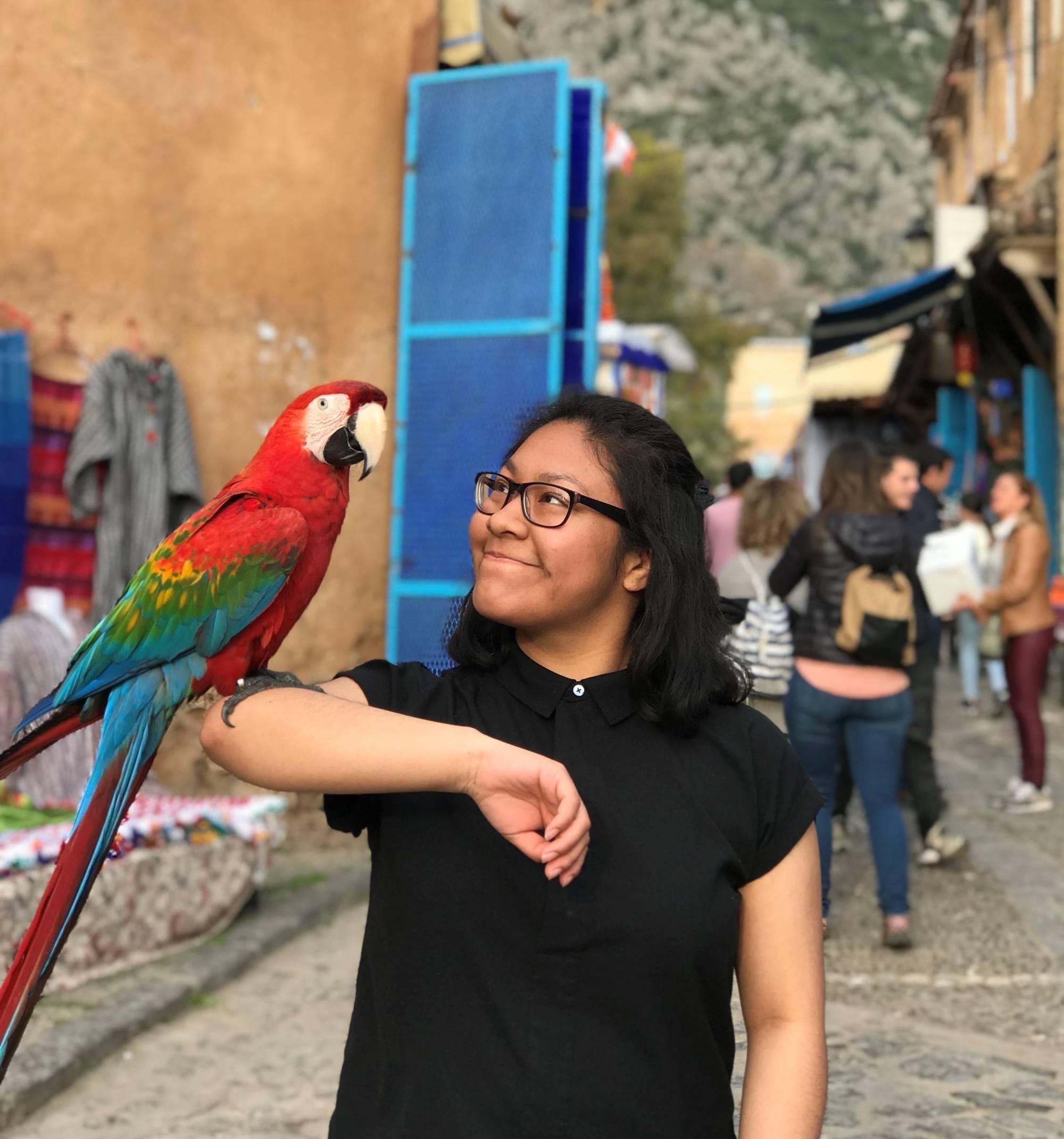 Student with a parrot on their arm in Spain